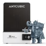 Anycubic Photon P1 Max resin printer front view beside a high-detail resin print showing 12K surface quality